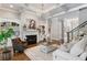 Elegant living room with fireplace, coffered ceiling, hardwood floors, and staircase at 12680 Old Surrey Pl, Roswell, GA 30075