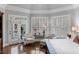 Bedroom sitting area featuring French doors, plantation shutters, and hardwood floors at 12680 Old Surrey Pl, Roswell, GA 30075