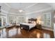 Spacious main bedroom with hardwood floors, tray ceiling, and plantation shutters at 12680 Old Surrey Pl, Roswell, GA 30075
