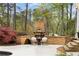 Cozy outdoor fireplace with stone surround and comfortable seating, perfect for entertaining at 12680 Old Surrey Pl, Roswell, GA 30075