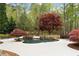Beautiful in-ground pool with stone accents, lush landscaping, and patio seating at 12680 Old Surrey Pl, Roswell, GA 30075