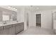 Modern bathroom featuring double sinks, marble tile floors, and separate shower and toilet rooms at 13567 Tolstoy Drive, Covington, GA 30014