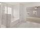 Modern bathroom featuring a bathtub, shower, and an open view to the main bedroom at 13567 Tolstoy Drive, Covington, GA 30014