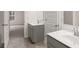 Modern bathroom with double sinks, white countertops, and tiled floors at 13567 Tolstoy Drive, Covington, GA 30014