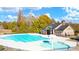Large community pool with a splash pad, surrounded by lush landscaping, and a pool house at 13567 Tolstoy Drive, Covington, GA 30014