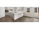 Open-concept kitchen with breakfast bar, gray cabinets, stainless appliances, and hardwood floors at 13567 Tolstoy Drive, Covington, GA 30014