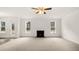 Spacious living room with a modern fireplace, large windows, and neutral carpet at 13567 Tolstoy Drive, Covington, GA 30014