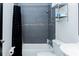 Bathroom with a shower-tub combo and a gray tile surround at 240 W Lake Nw Dr, Atlanta, GA 30314
