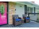Inviting front porch with a cozy seating area and stylish pink front door at 240 W Lake Nw Dr, Atlanta, GA 30314