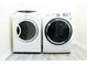 Bright laundry room featuring a modern washer and dryer set on gray wood-look floor at 240 W Lake Nw Dr, Atlanta, GA 30314