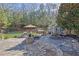 Expansive backyard featuring a stone patio with a firepit, spa, shed, and outdoor seating at 3740 Williams Point Dr, Cumming, GA 30028