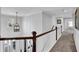 Well-lit hallway with hardwood railing overlooking the staircase and carpeted floor leading to rooms at 3740 Williams Point Dr, Cumming, GA 30028