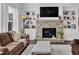 Bright living room featuring stone fireplace, built-in shelves, and comfortable seating at 3740 Williams Point Dr, Cumming, GA 30028
