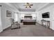 Spacious main bedroom features a tray ceiling, a ceiling fan, a large bed, and a sitting area at 3740 Williams Point Dr, Cumming, GA 30028