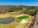 Overhead capture of a golf course featuring a water hazard and sand traps near a pristine green at 2025 Fairway Crossing Dr, Woodstock, GA 30188