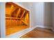 A view of the unfinished attic access reveals wooden supports and insulation, highlighting functional home features at 2025 Fairway Crossing Dr, Woodstock, GA 30188