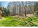 Expansive backyard with lush green grass and trees, offering a peaceful outdoor retreat and play area at 2025 Fairway Crossing Dr, Woodstock, GA 30188