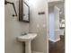 Bathroom features a pedestal sink, mirror, and access to other rooms, showcasing classic design at 2025 Fairway Crossing Dr, Woodstock, GA 30188
