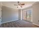 Cozy bedroom features plush carpeting, a ceiling fan, and a large window offering natural light at 2025 Fairway Crossing Dr, Woodstock, GA 30188