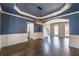 Elegant dining room with hardwood floors, navy blue walls, and modern light fixture, connected to kitchen at 2025 Fairway Crossing Dr, Woodstock, GA 30188