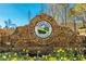 Stone entrance sign reading 'Bradshaw Farm, A Golf Club Community' with flowers, welcoming residents and visitors at 2025 Fairway Crossing Dr, Woodstock, GA 30188