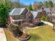 Spacious brick home with lush landscaping, mature trees, and a well-manicured front yard at 2025 Fairway Crossing Dr, Woodstock, GA 30188