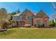 Charming brick home with a well-maintained lawn and inviting curb appeal on a sunny day at 2025 Fairway Crossing Dr, Woodstock, GA 30188
