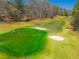 Beautiful green golf course featuring trees, sand traps, and golfers playing in this luxury community at 2025 Fairway Crossing Dr, Woodstock, GA 30188