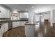Open kitchen with granite counters, stainless appliances, and white cabinets overlooking adjacent living spaces at 2025 Fairway Crossing Dr, Woodstock, GA 30188