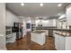 Spacious kitchen features stainless steel appliances, white cabinetry, granite countertops, and a center island at 2025 Fairway Crossing Dr, Woodstock, GA 30188