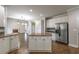 Open kitchen featuring granite countertops, stainless steel appliances, island, and seamless flow to living area at 2025 Fairway Crossing Dr, Woodstock, GA 30188
