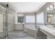 Bright main bathroom with double vanity, jacuzzi tub, and glass enclosed shower at 2025 Fairway Crossing Dr, Woodstock, GA 30188