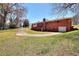 View of backyard showing the property's well-manicured lawn, driveway, and brick home at 1420 Stephenson Rd, Lithonia, GA 30058