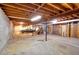 Unfinished basement with exposed wooden beams, brick walls, and a classic car at 1420 Stephenson Rd, Lithonia, GA 30058