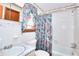 Bathroom with white tile, colorful shower curtain, marble-style countertop and traditional fixtures at 1420 Stephenson Rd, Lithonia, GA 30058