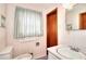 Bright bathroom with white vanity, patterned wallpaper, and a large window with striped curtains at 1420 Stephenson Rd, Lithonia, GA 30058