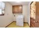 Practical laundry area with a washing machine and wooden cabinets for storage at 1420 Stephenson Rd, Lithonia, GA 30058