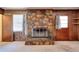 Living room featuring a stone fireplace, wood paneling, and windows with curtains at 1420 Stephenson Rd, Lithonia, GA 30058
