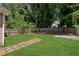 Backyard with a path made of stone squares surrounded by a large lawn and a wooden fence at 1615 Orlando Sw St, Atlanta, GA 30311