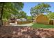 Backyard with a gravel driveway, new grass, a wooden fence, and trees at 1615 Orlando Sw St, Atlanta, GA 30311