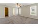 Spacious bedroom with soft carpet, a ceiling fan, closet access, and natural light from two windows at 1715 Eden Valley Ct, Loganville, GA 30052
