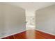 Hallway showing hardwood flooring with open view to dining area, neutral paint, and electrical outlets at 1715 Eden Valley Ct, Loganville, GA 30052