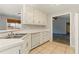 Kitchen boasts white cabinets, bright countertops, tile floors and stainless-steel dishwasher at 1715 Eden Valley Ct, Loganville, GA 30052