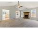 Spacious living room featuring carpet flooring, a stone fireplace, a ceiling fan, and a pass through to the kitchen at 1715 Eden Valley Ct, Loganville, GA 30052