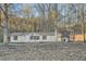 Single-story home with a storage shed in a spacious yard with mature trees surrounding the property at 355 Double D Rd, Temple, GA 30179