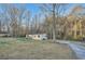Single-story home surrounded by trees and an ample front yard and long driveway at 355 Double D Rd, Temple, GA 30179