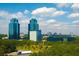 Modern glass office buildings rising high above the treeline against a beautiful blue sky at 6701 Prelude Dr, Atlanta, GA 30328