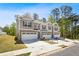 Three newly built townhomes featuring a brick facade, attached garages, and a well-manicured lawn at 1180 Cades Walk, Lawrenceville, GA 30045