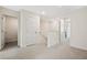 Hallway with neutral walls and carpet, featuring multiple doorways and stairs to the upper level at 1180 Cades Walk, Lawrenceville, GA 30045