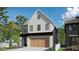 Charming two-story home with white siding, black trim, and a two-car garage with decorative wood doors at 2595 Apple Valley Rd, Brookhaven, GA 30319